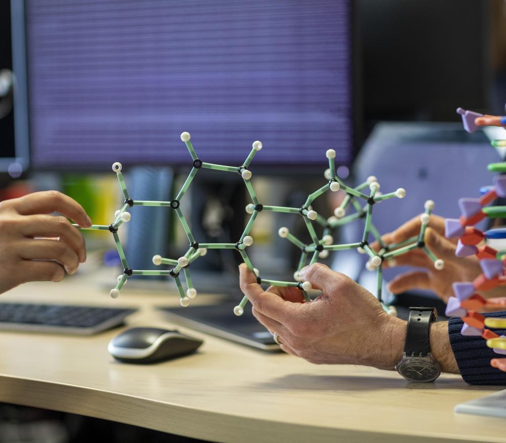 A model of a molecule being held on a desk.