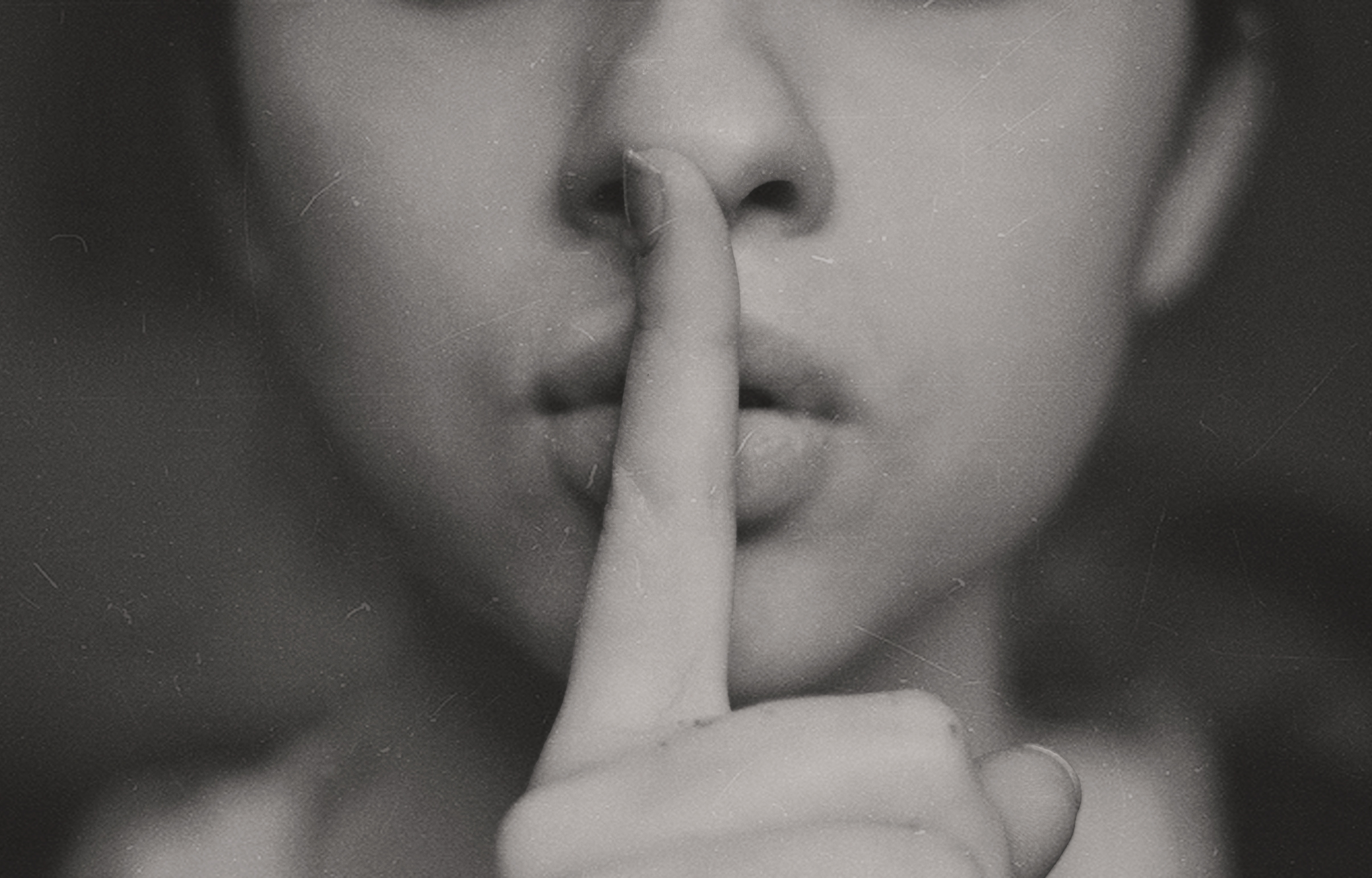 A photo of a woman with her finger on her lips