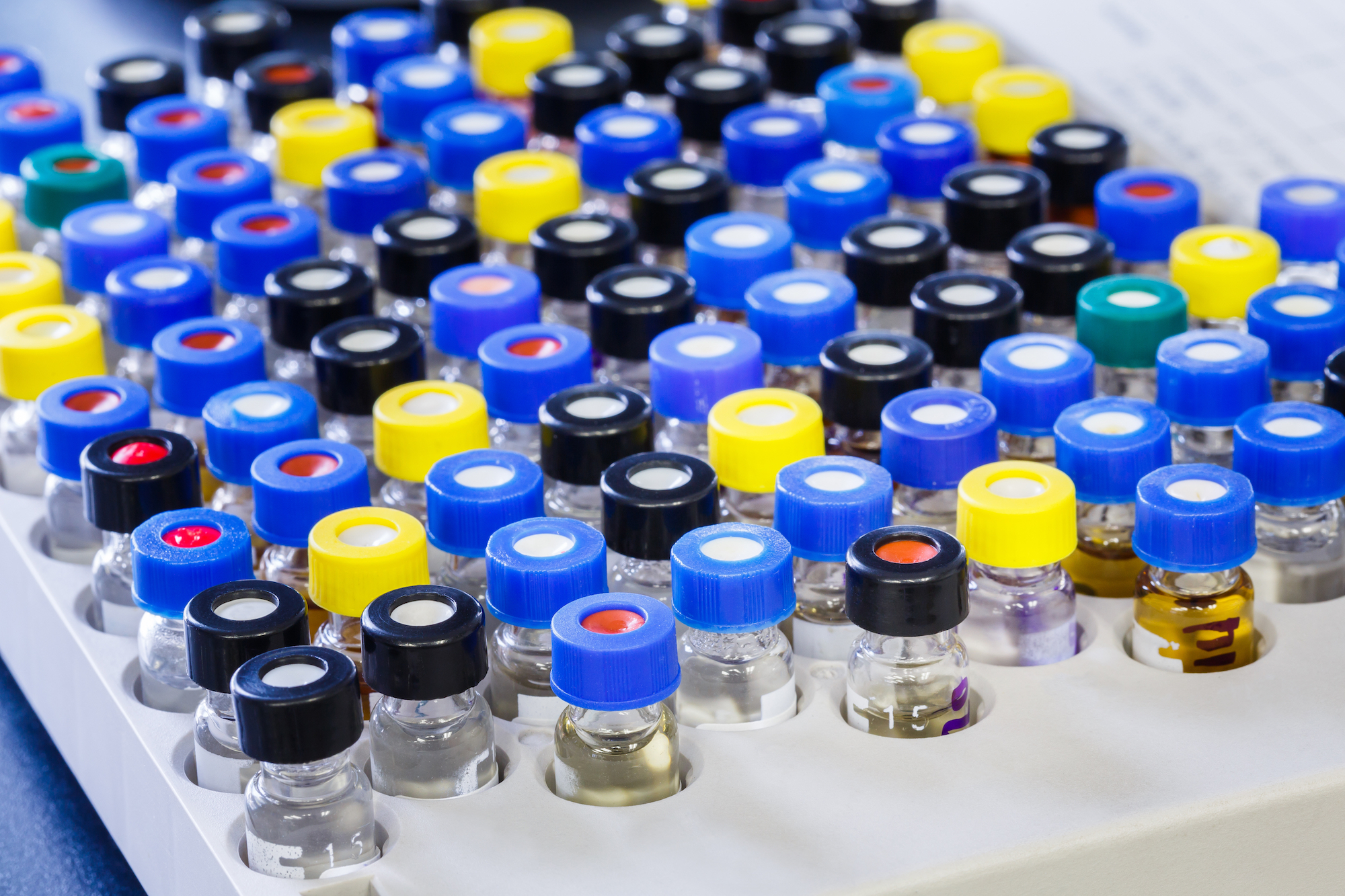 Photo of vials with inserts and crimp septum caps in plastic rack for liquid analysis