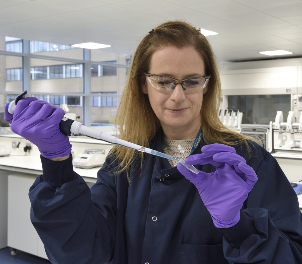 A scientist pipetting in a laboratory.