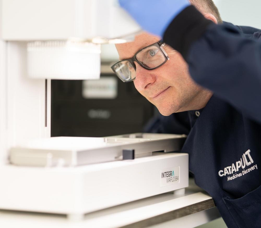 A scientist using a drug discovery machine in a laboratory.