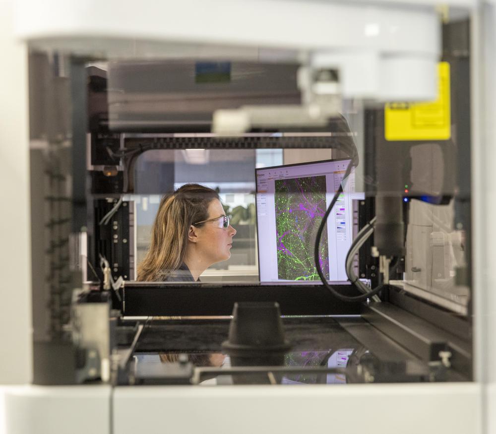 A scientist using a computer through a machine in a laboratory.