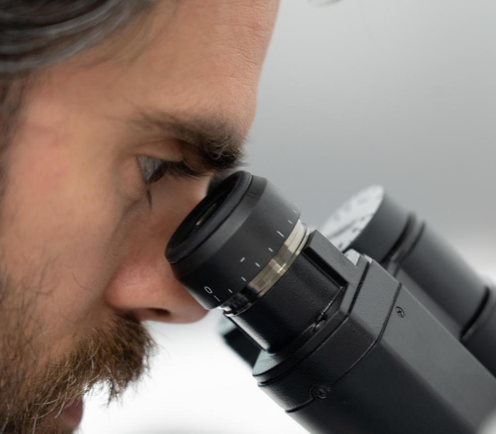 A scientist looking into a microscope.